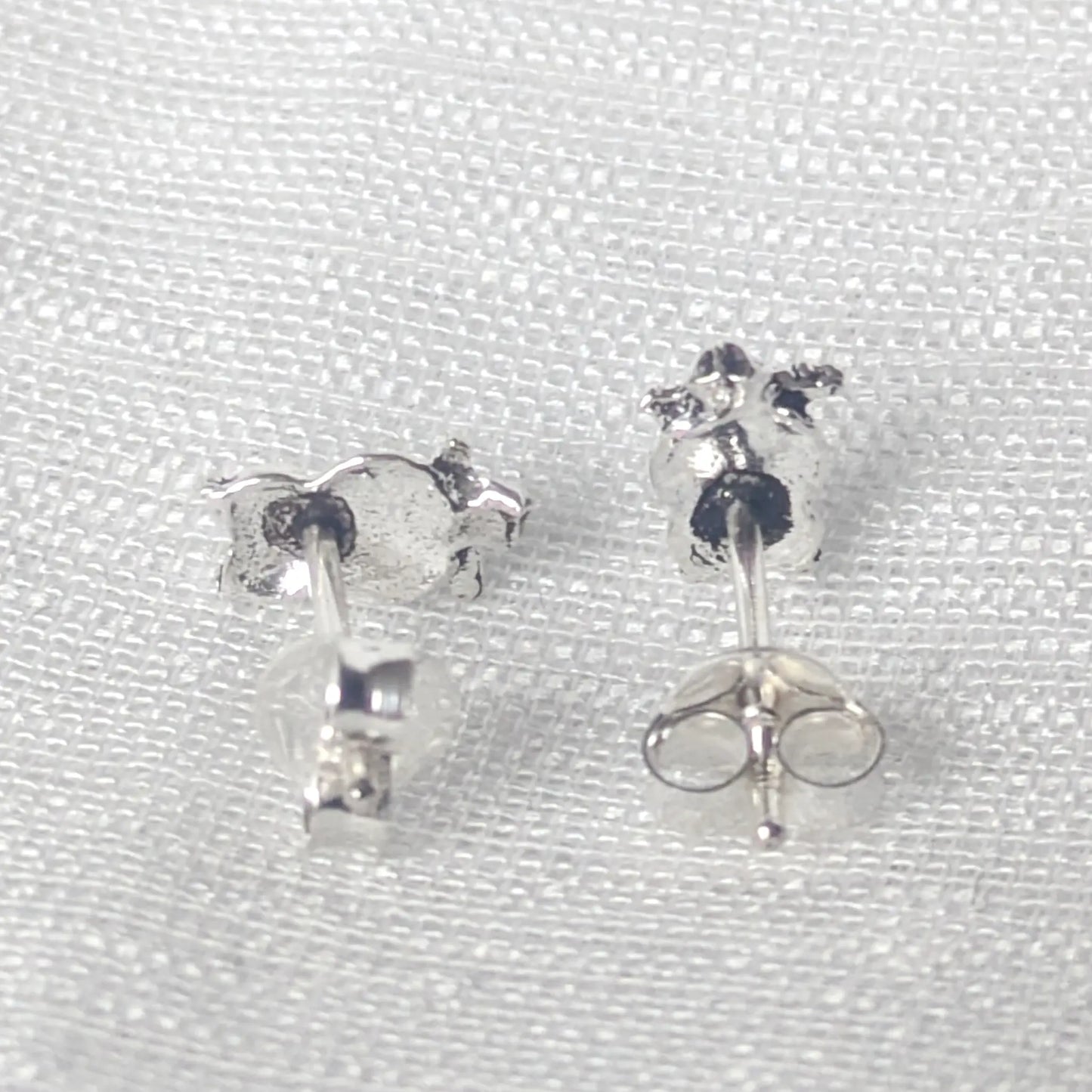 Rückansicht der Eulen-Ohrstecker aus 925 Sterling Silber auf weißem Stoff fotografiert.
