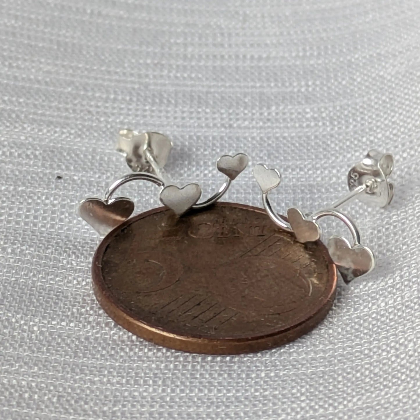 Größenvergleich der Herz-Ohrstecker auf einer 5-Cent Münze zur Maßstabsdarstellung.