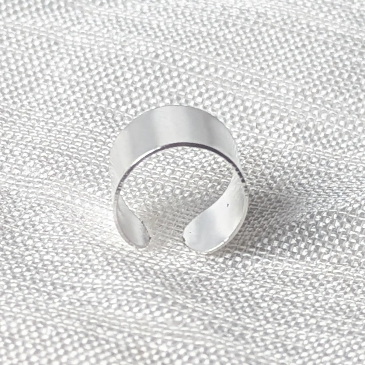 Seitenansicht des breiten Ear Cuffs aus Silber zur Veranschaulichung der halbrunden Passform.