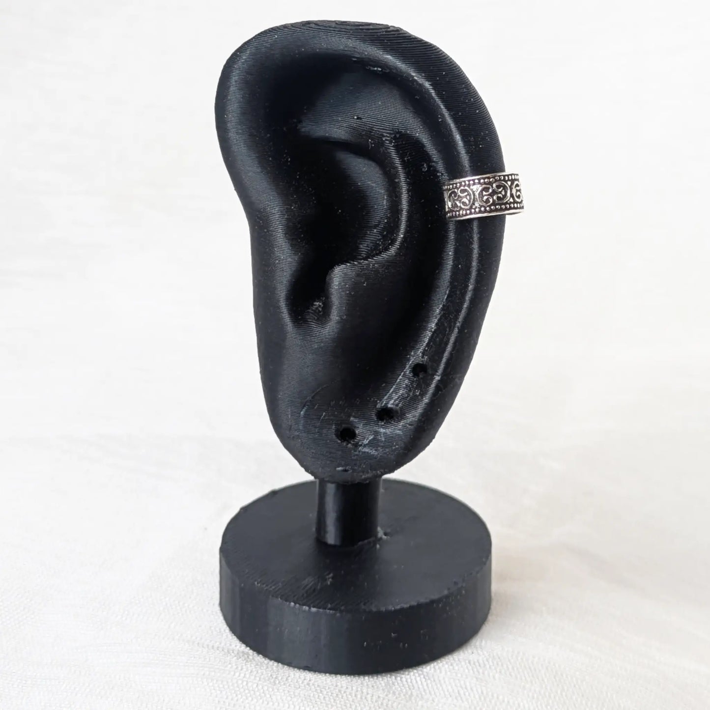 Earcuff Silber 925 am schwarzen Ohr mit filigranen Ornamenten Display Präsentation