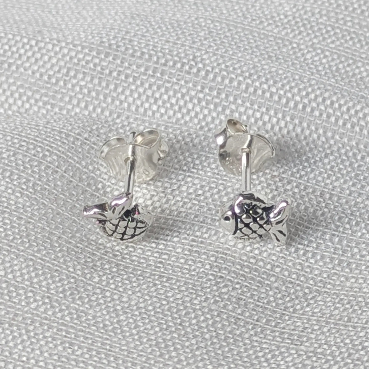 Frontalansicht eines kleinen Fisch Ohrsteckers aus oxidiertem 925 Sterling Silber.
