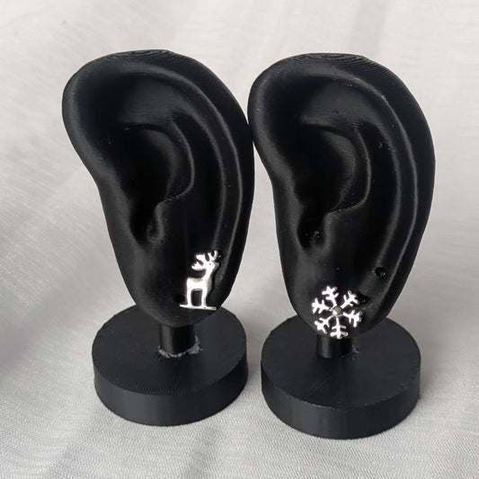 Präsentation der Hirsch- und Schneeflocken-Ohrringe an einem schwarzen Display für die Trageoptik.