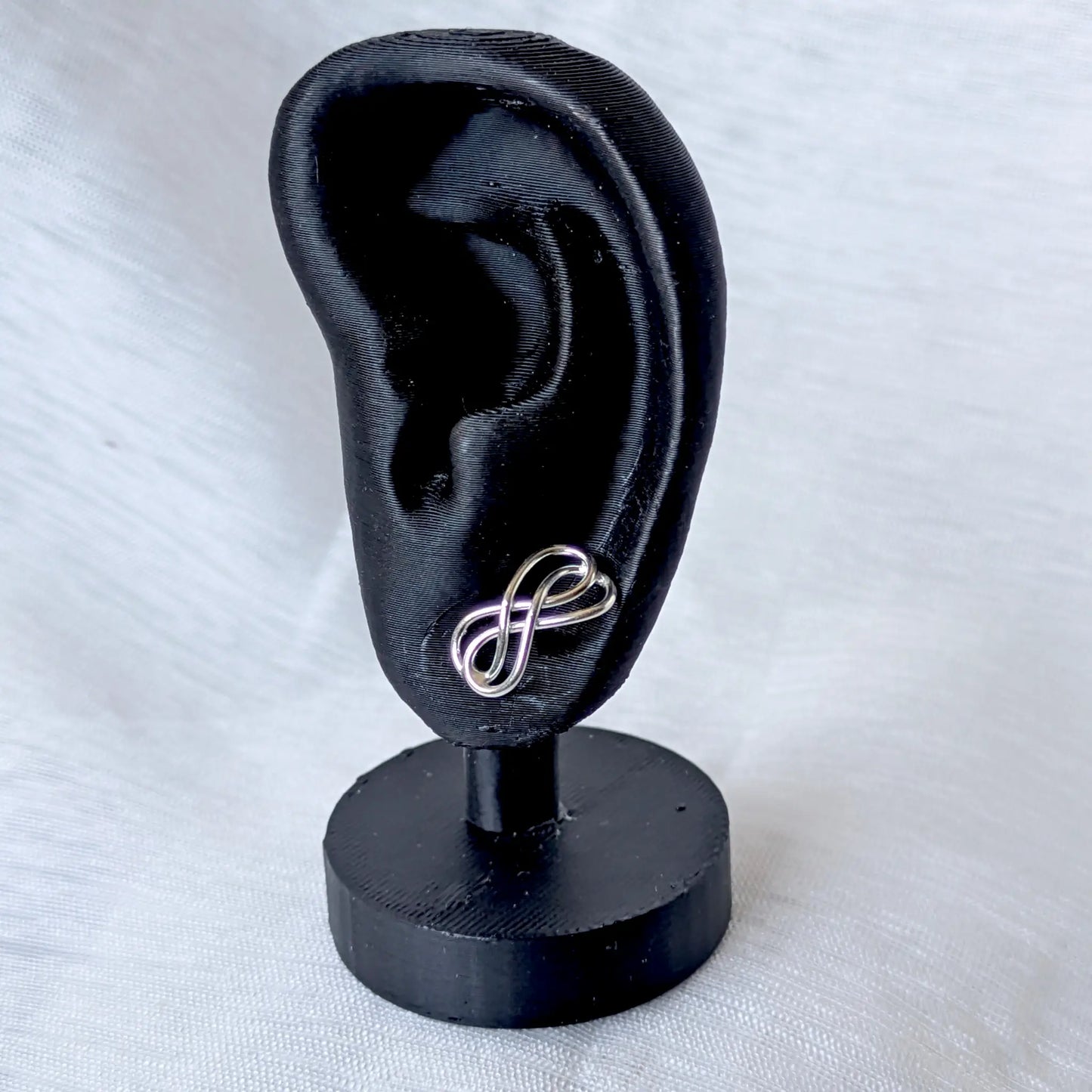 Infinity Ohrstecker 925 Silber getragen am schwarzen Ohr-Display zur Größenansich