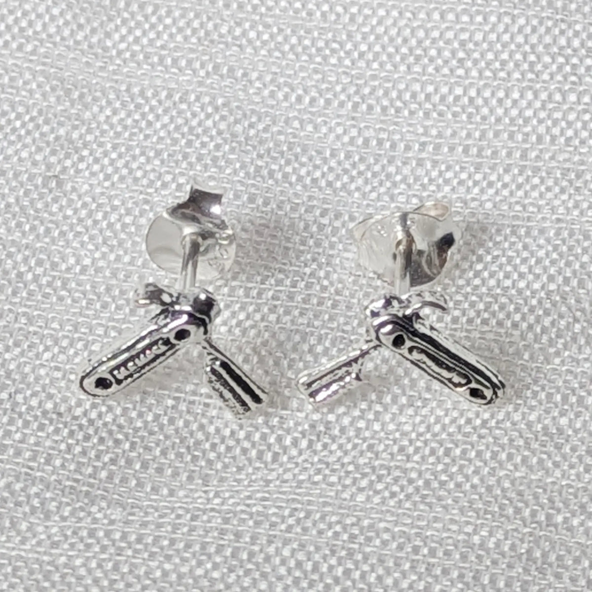 Frontalansicht der Rasiermesser-Ohrringe aus Silber mit geschwärzten Details am Griff und glänzender Klinge.