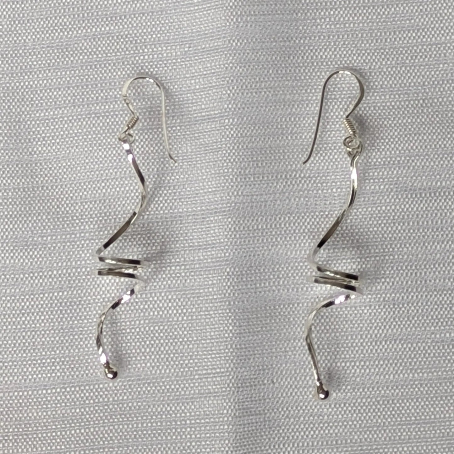 Detailansicht der glänzenden Oberfläche der 925 Silber Spiral-Ohrhänger.