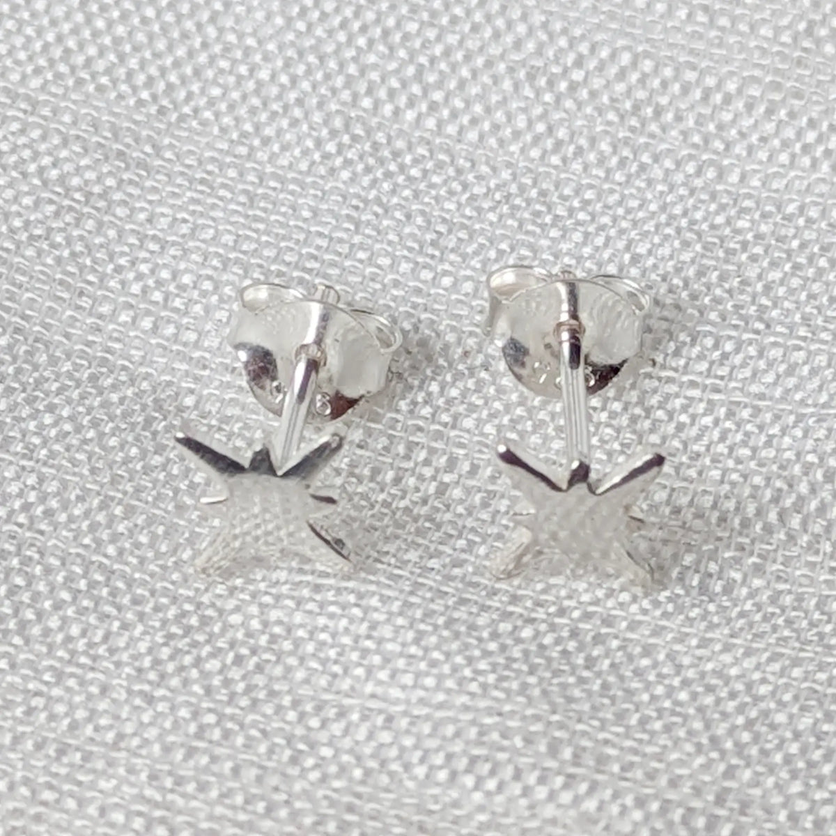 Frontalansicht eines kleinen asymmetrischen Nordstern-Ohrsteckers aus 925 Sterlingsilber.
