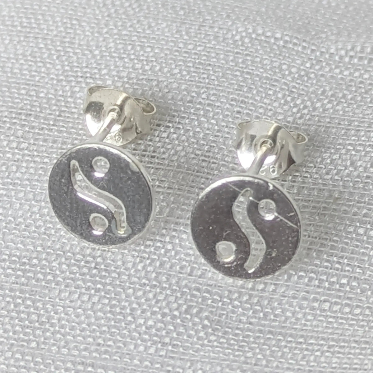 Frontale Ansicht der flachen silbernen Yin-Yang-Stecker.