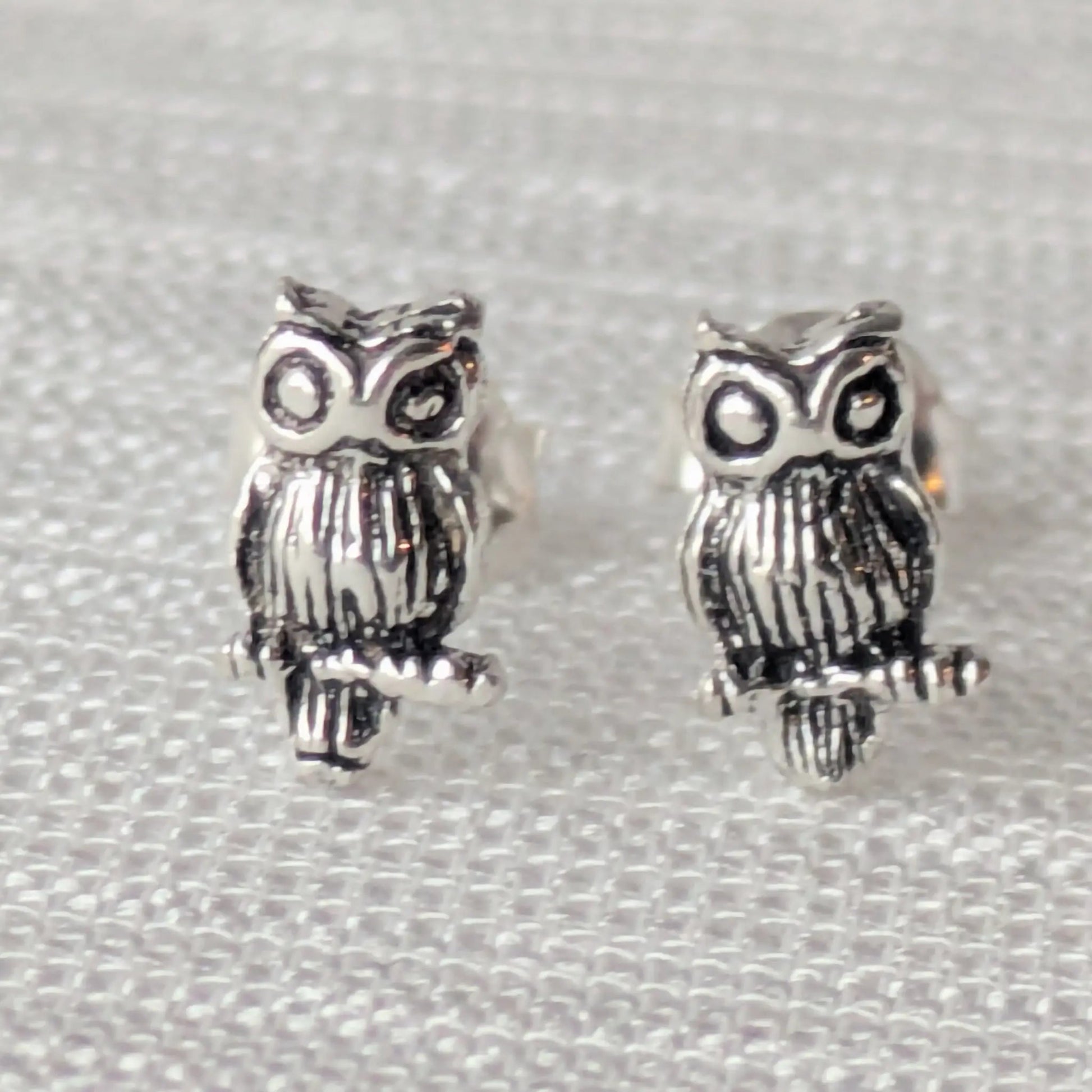 Paar detaillierte Eulen-Ohrstecker aus 925 Sterling Silber auf weißem Hintergrund.
