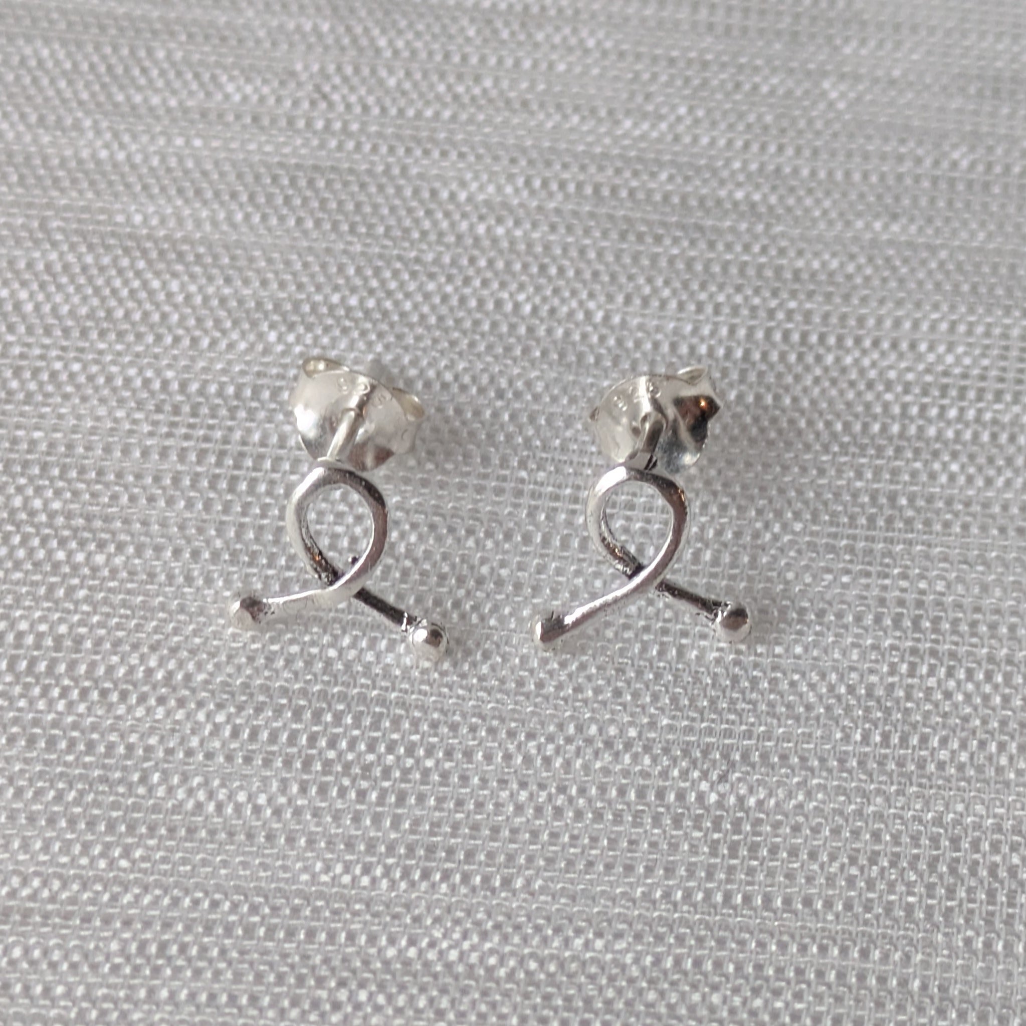 Elegante Awareness-Schleifen aus 925er Silber – zarte Ohrstecker in Nahaufnahme