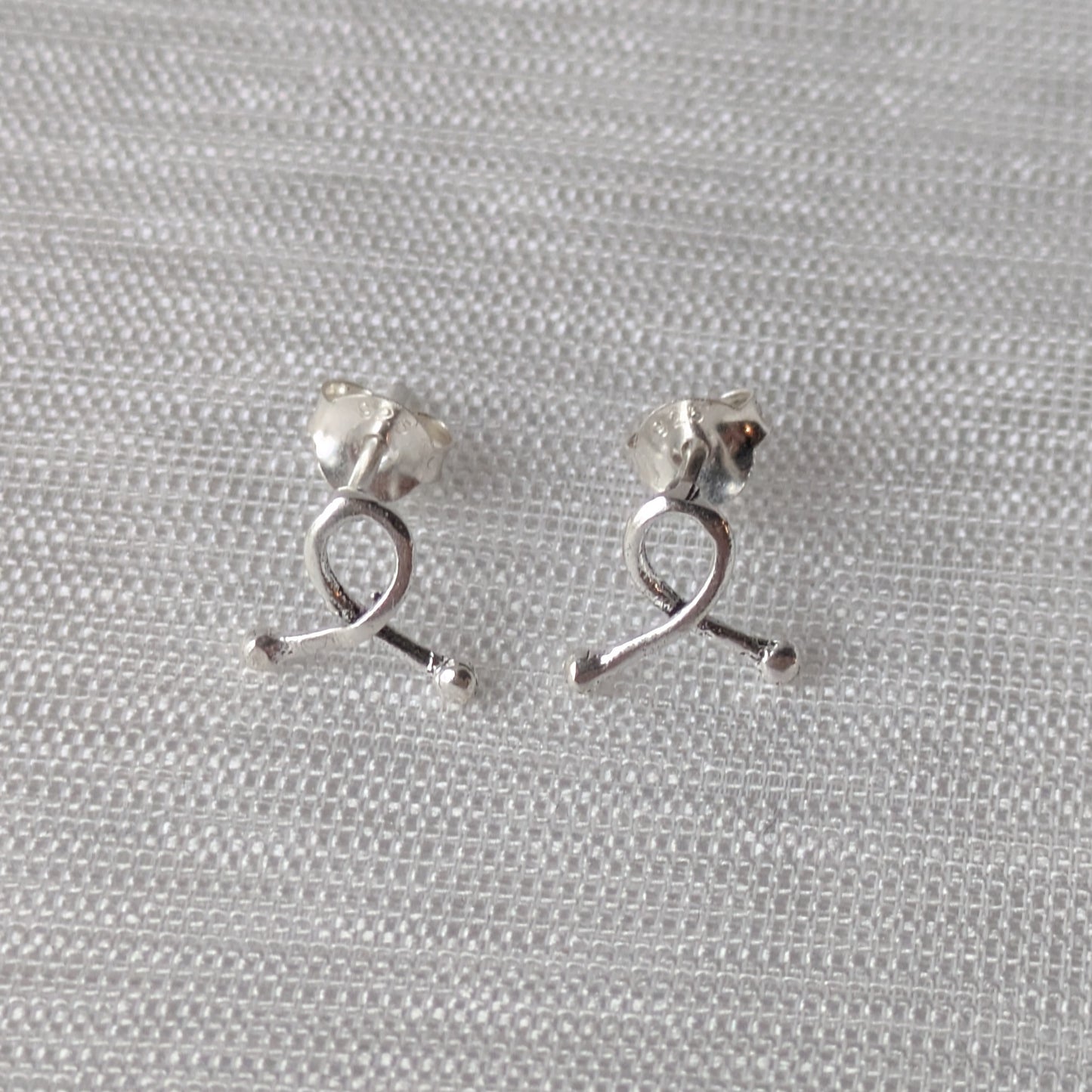 Elegante Awareness-Schleifen aus 925er Silber – zarte Ohrstecker in Nahaufnahme