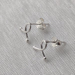 Lade das Bild in den Galerie-Viewer, Silberne Schleifen-Ohrringe mit glänzender Oberfläche, stilvoll arrangiert
