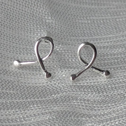Mini-Ribbon Ohrstecker aus 925er Silber auf hellem Stoffhintergrund
