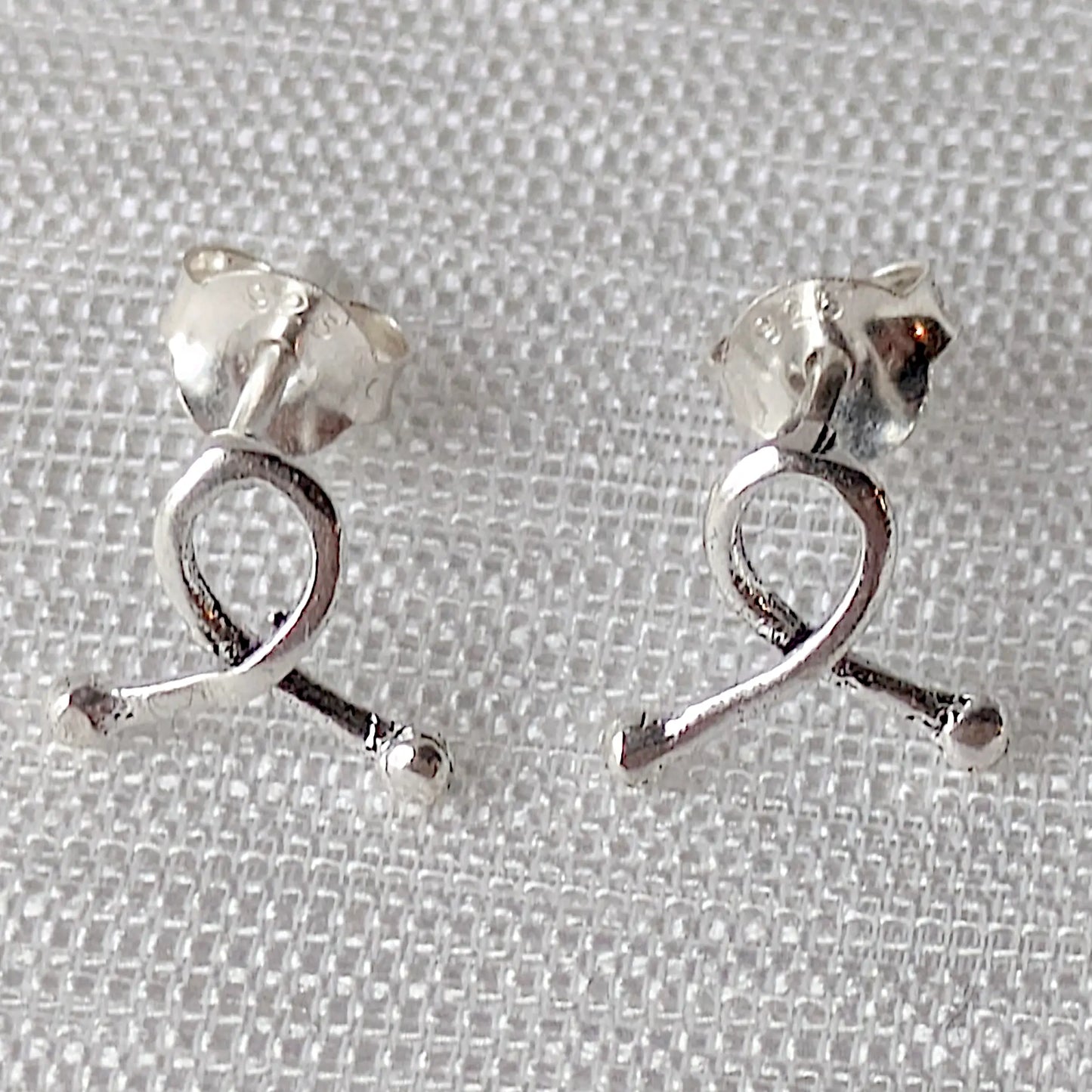 Frontalansicht Elegante Awareness-Schleifen aus 925er Silber – zarte Ohrstecker in Nahaufnahme