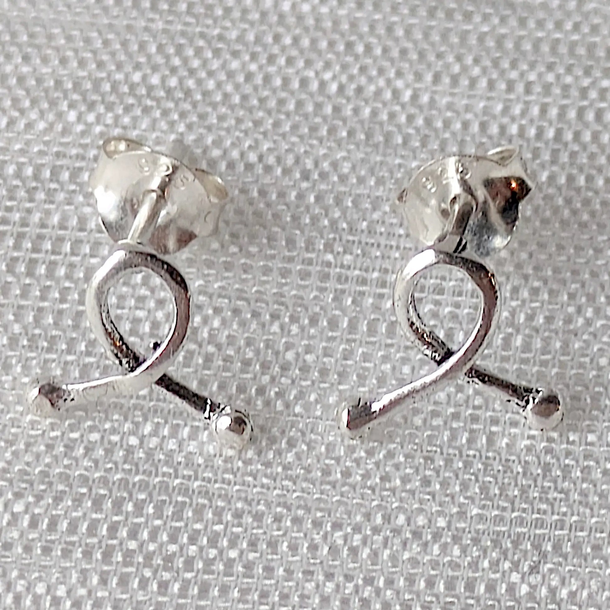 Frontalansicht Elegante Awareness-Schleifen aus 925er Silber – zarte Ohrstecker in Nahaufnahme