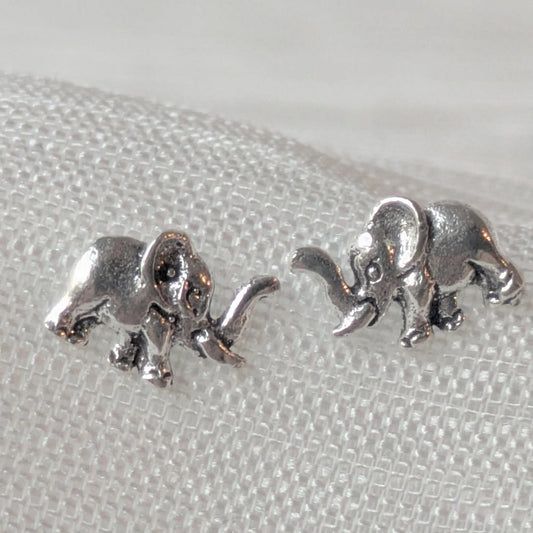 Nahaufnahme von zwei kleinen Elefanten-Ohrringen aus echtem Silber, ideal als Ohrstecker für Tierliebhaber.