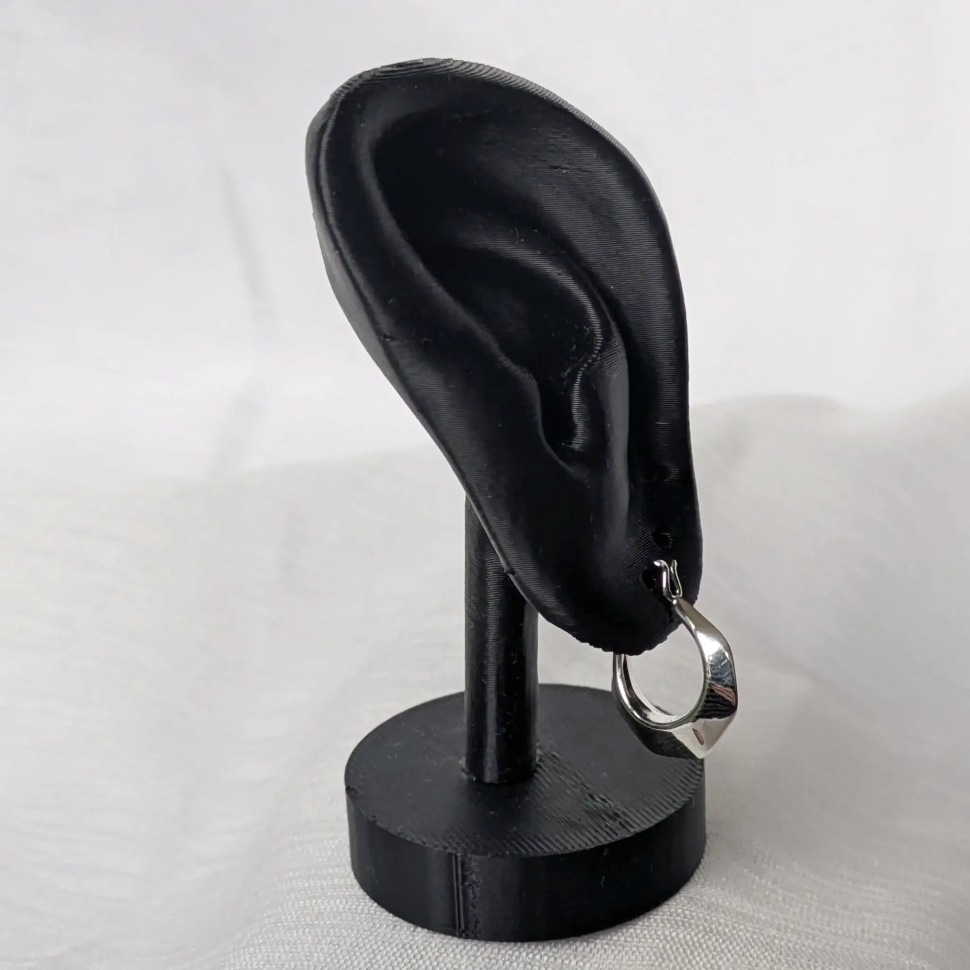 Elegante Präsentation der kleinen kantigen Creolen an einem schwarzen Schmuckhalter.