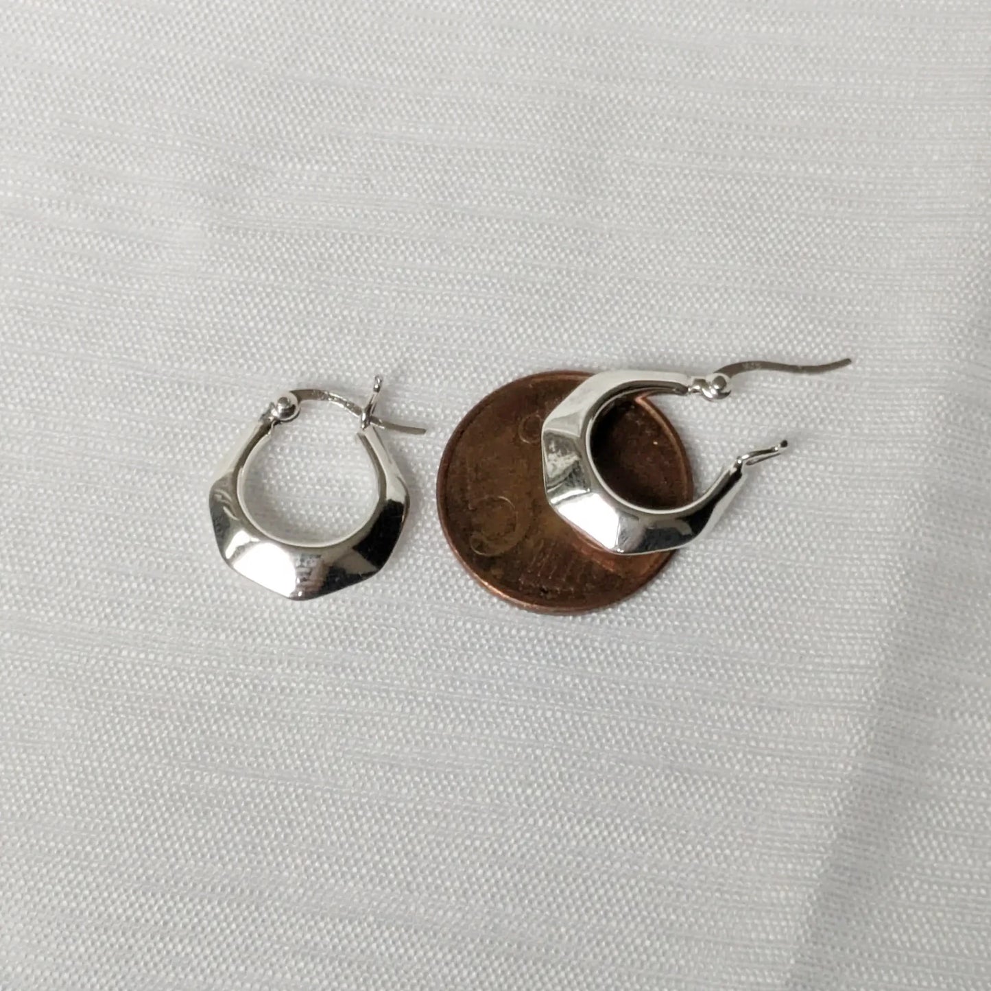Größenvergleich der kleinen Silber-Ohrringe auf einer 5-Cent-Münze zur Veranschaulichung.