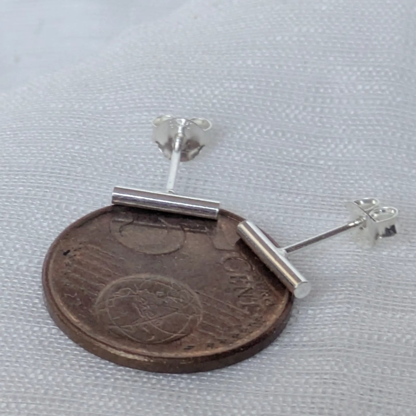 Größenvergleich der minimalistischen Silber-Ohrringe 10mm auf einer 5-Cent-Münze zur Maßstäblichkeit.