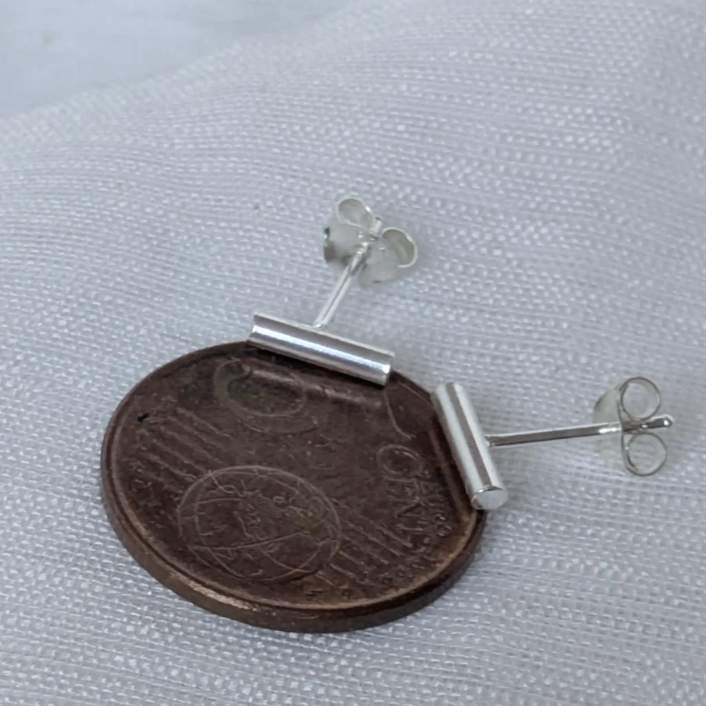 Größenvergleich der minimalistischen Silber-Ohrringe 8mm auf einer 5-Cent-Münze zur Maßstäblichkeit.