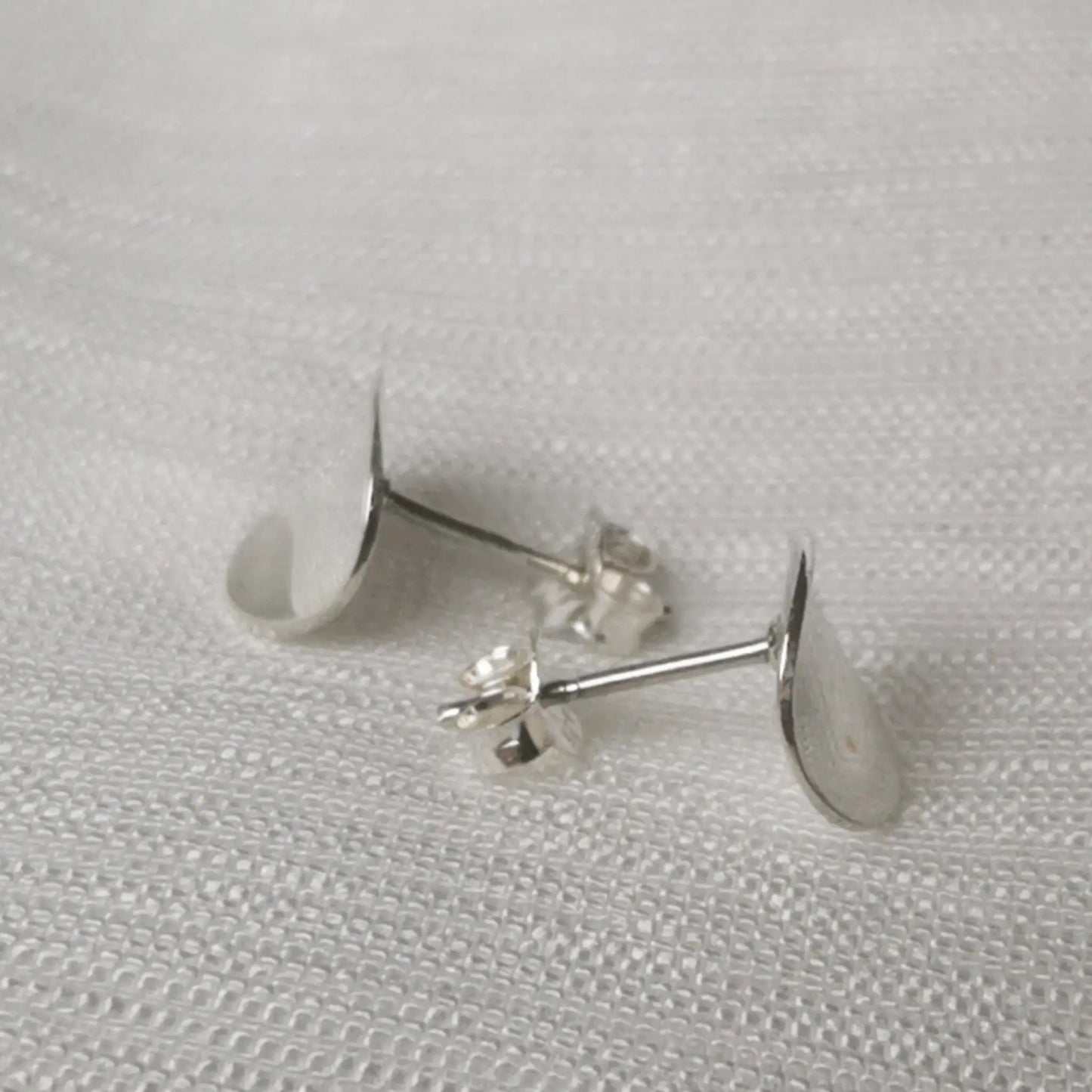 Seitenansicht der flachen Disc-Ohrstecker zur Verdeutlichung des schmalen, gewölbten Designs.