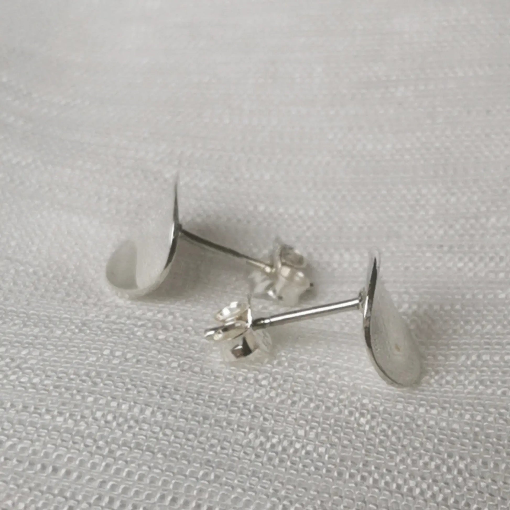 Seitenansicht der flachen Disc-Ohrstecker zur Verdeutlichung des schmalen, gewölbten Designs.