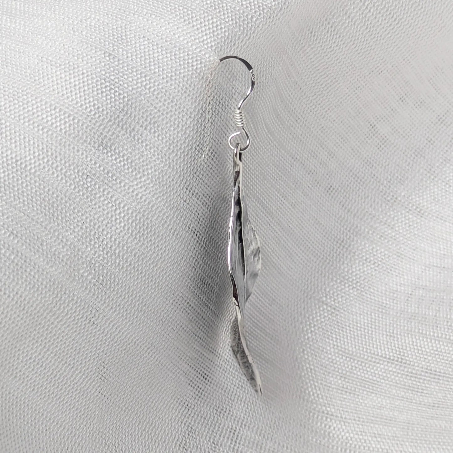 Seitenansicht der silbernen Blattschmuck-Ohrringe zur Darstellung der flachen, organisch geschwungenen Form.