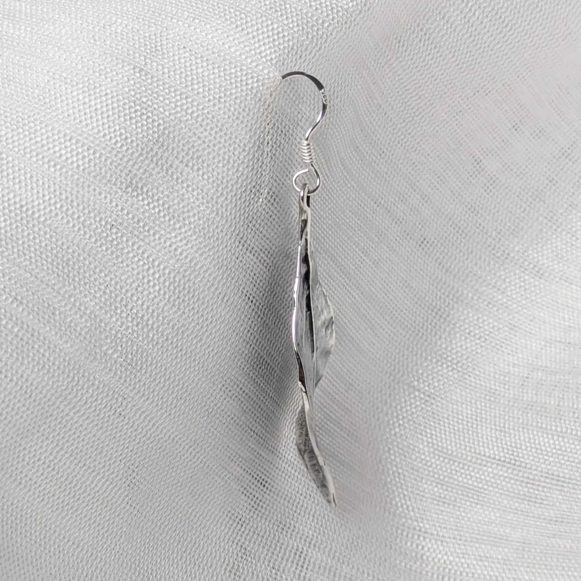 Seitenansicht der silbernen Blattschmuck-Ohrringe zur Darstellung der flachen, organisch geschwungenen Form.