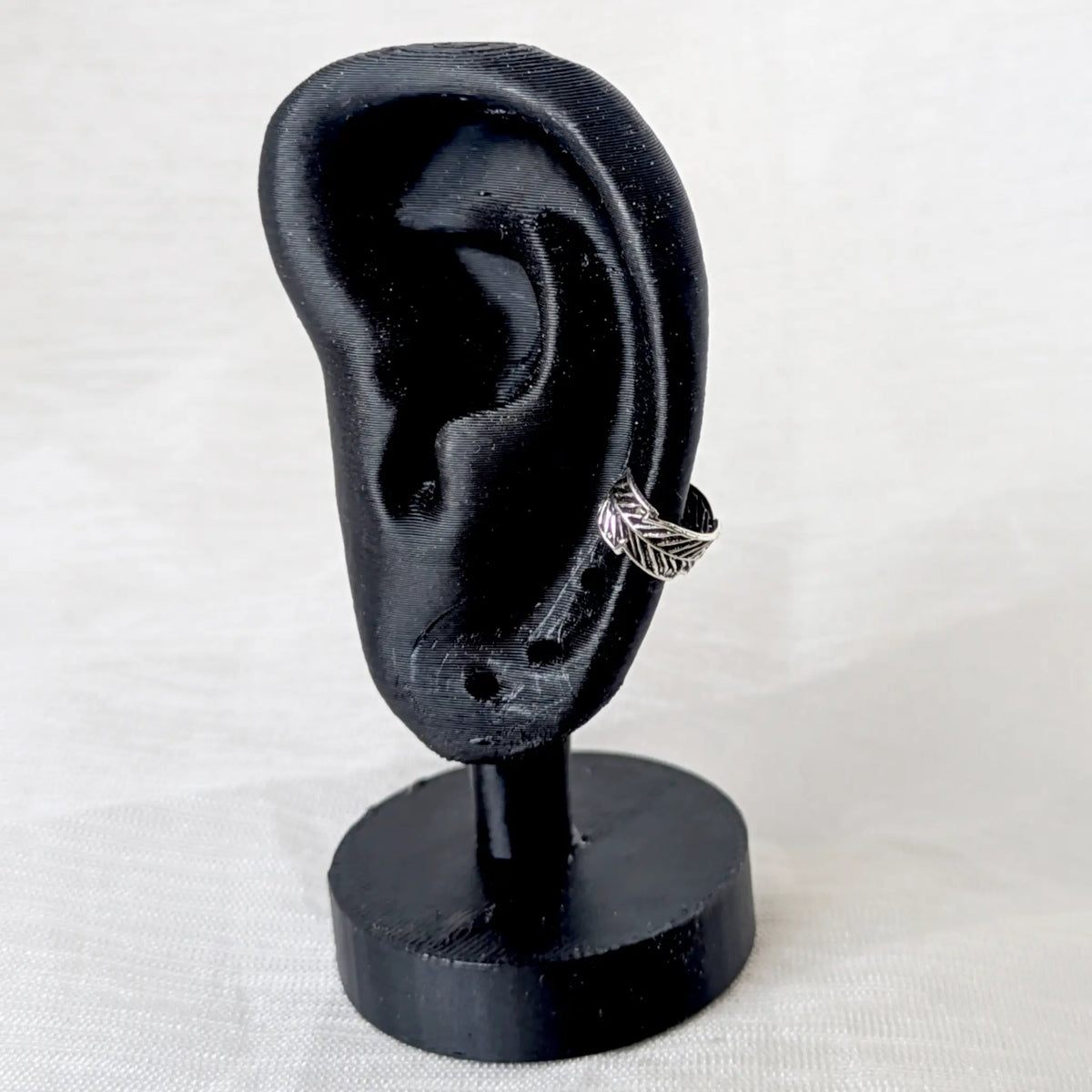 Feder Ear Cuff Silber 925 als Ohrklemme getragen am schwarzen Ohr-Display