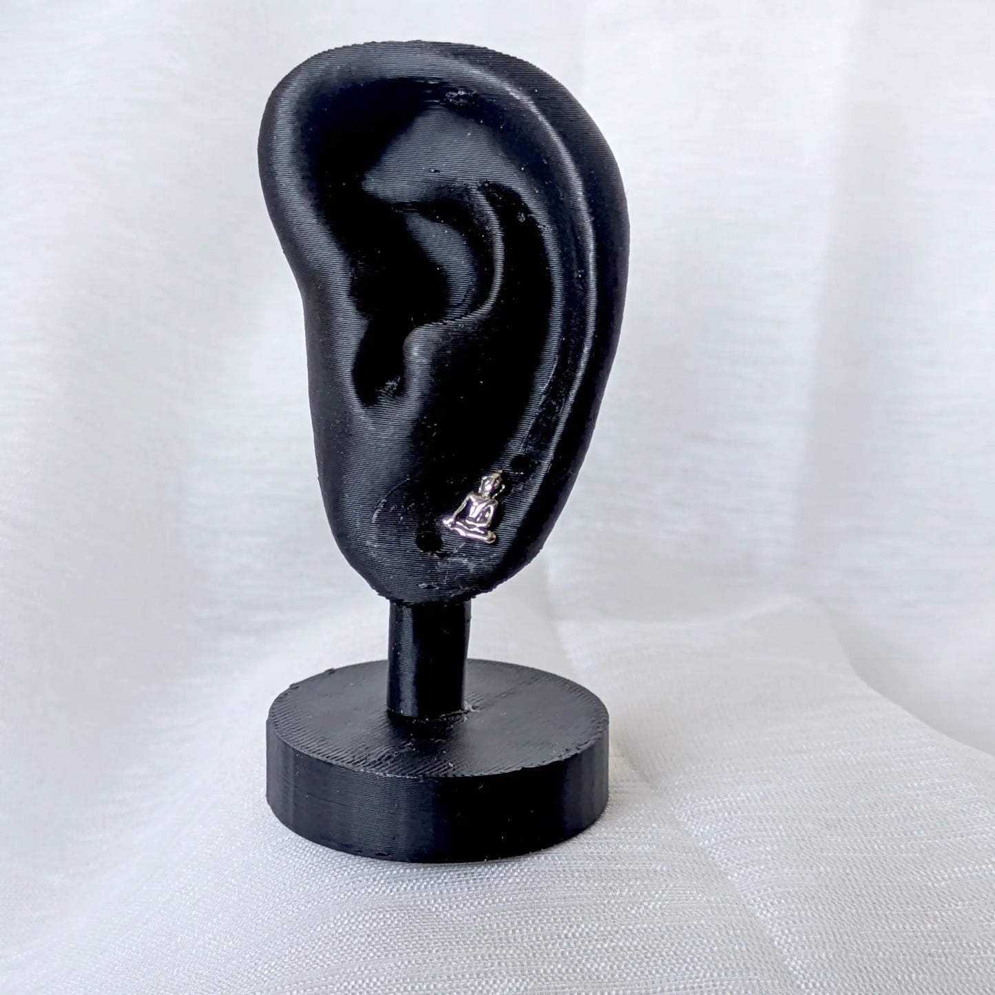 Filigraner Buddha Ohrstecker aus 925 Silber getragen an einem schwarzen Ohr-Display.