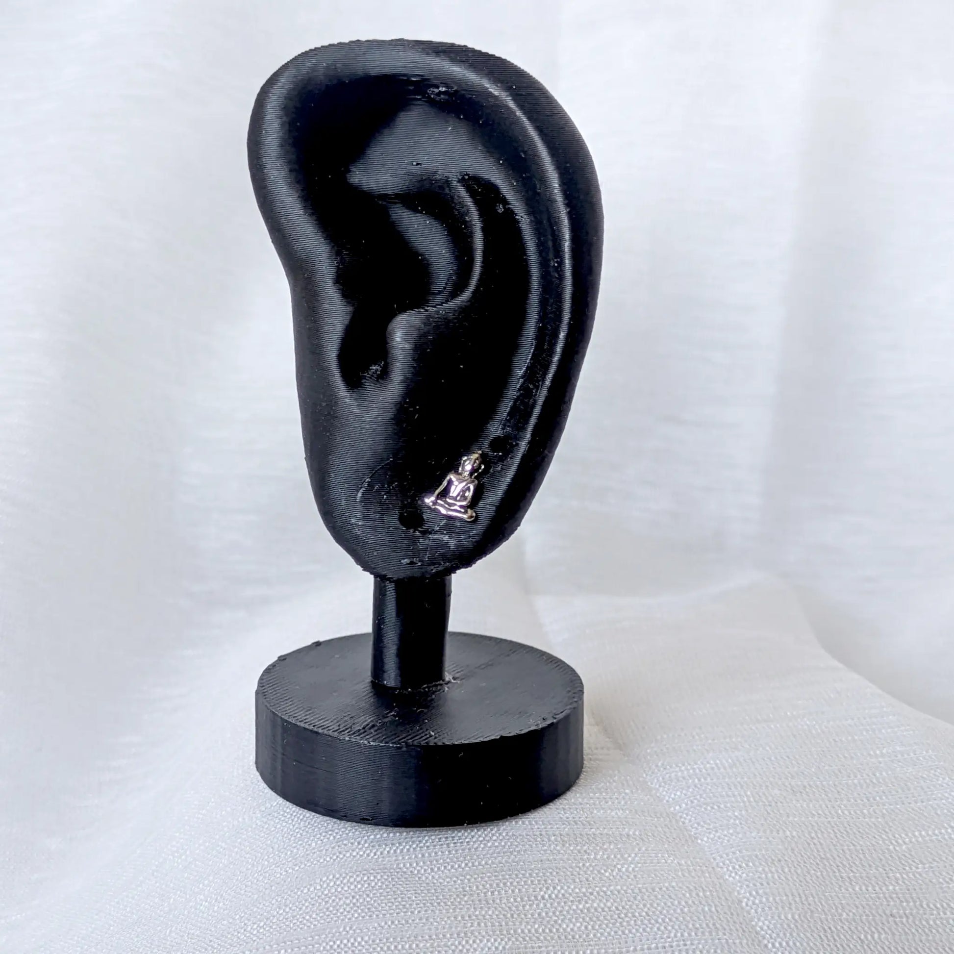 Filigraner Buddha Ohrstecker aus 925 Silber getragen an einem schwarzen Ohr-Display.