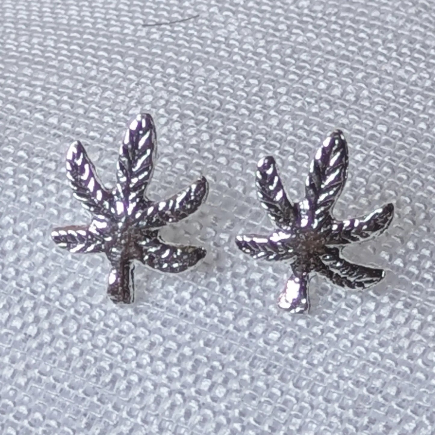 Nahaufnahme Cannabis Ohrstecker aus 925 Silber mit detaillierter Hanfblatt-Struktur