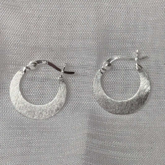 Detail der gebürsteten Struktur der 925 Silber Creolen in Sichelform.