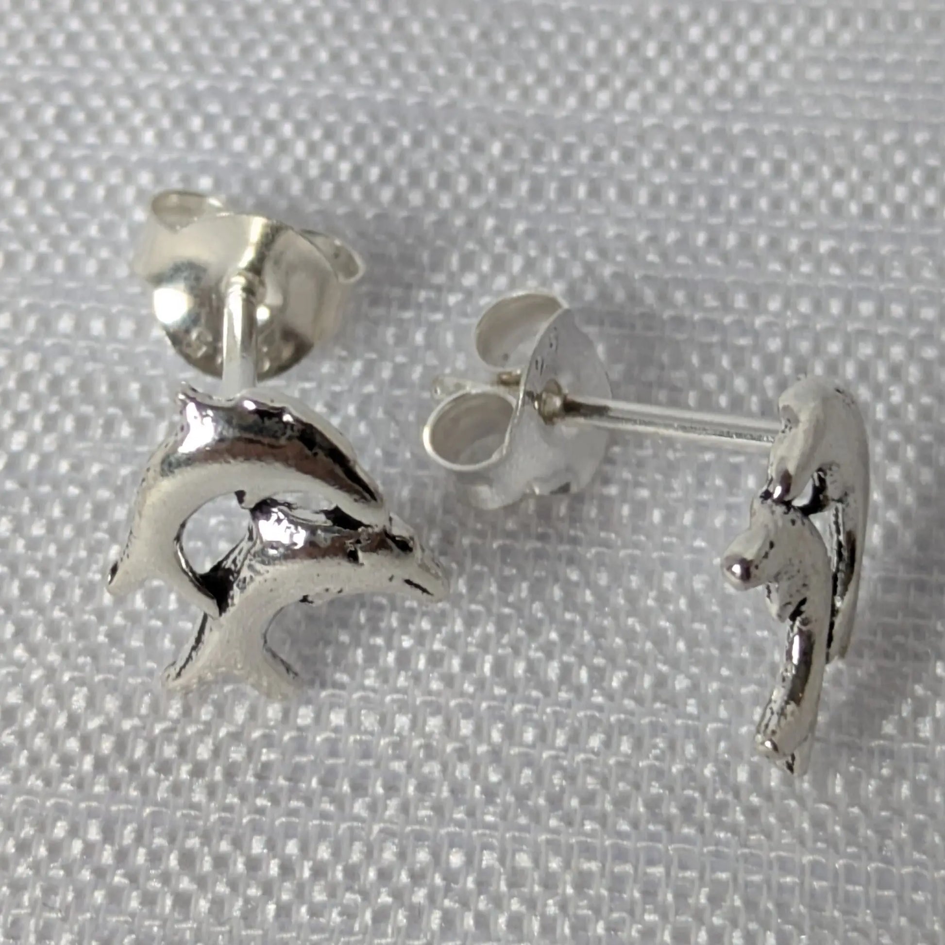Seitenansicht silberne Delfinstecker mit Verschluss-Detail.