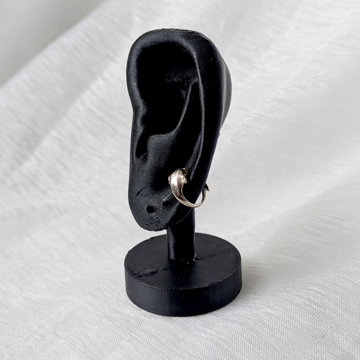 Maritimer Silber Ear Cuff Delfin getragen am schwarzen Ohrmodell zur Veranschaulichung der dynamischen Passform.