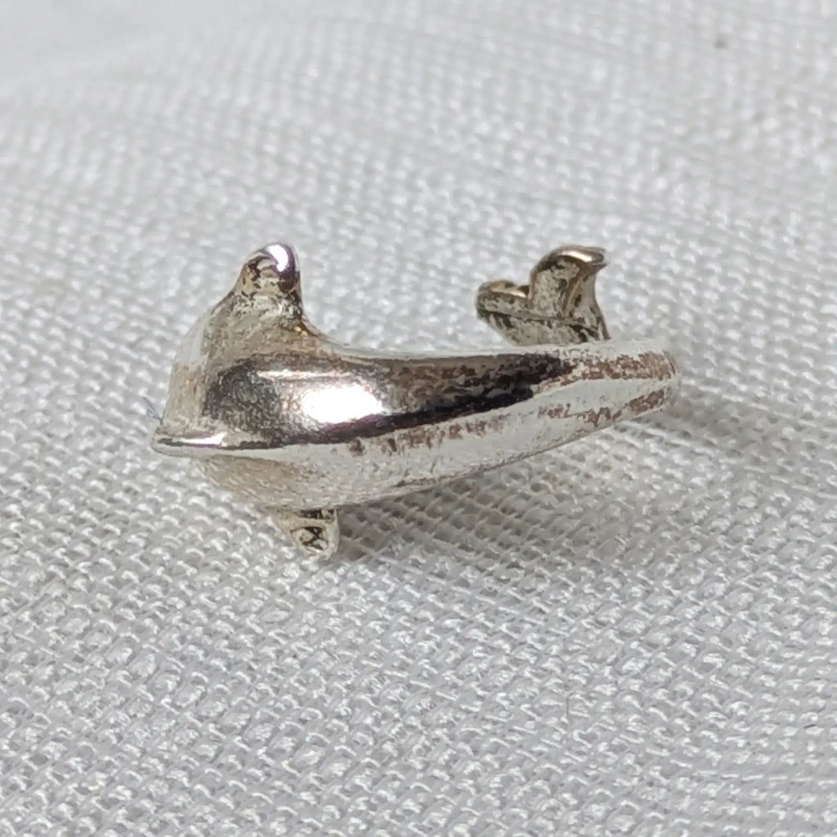 Rückseite und leicht geöffnete innere Struktur der geschwungenen Delfin Earcuff aus 925 Silber.