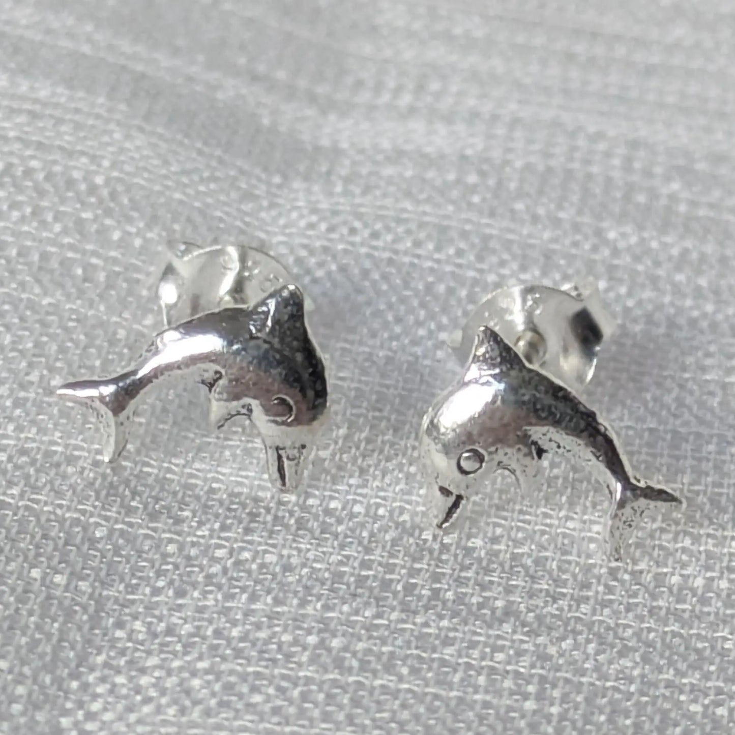 Frontale Ansicht der Delfin Silber Ohrstecker auf weißem Hintergrund