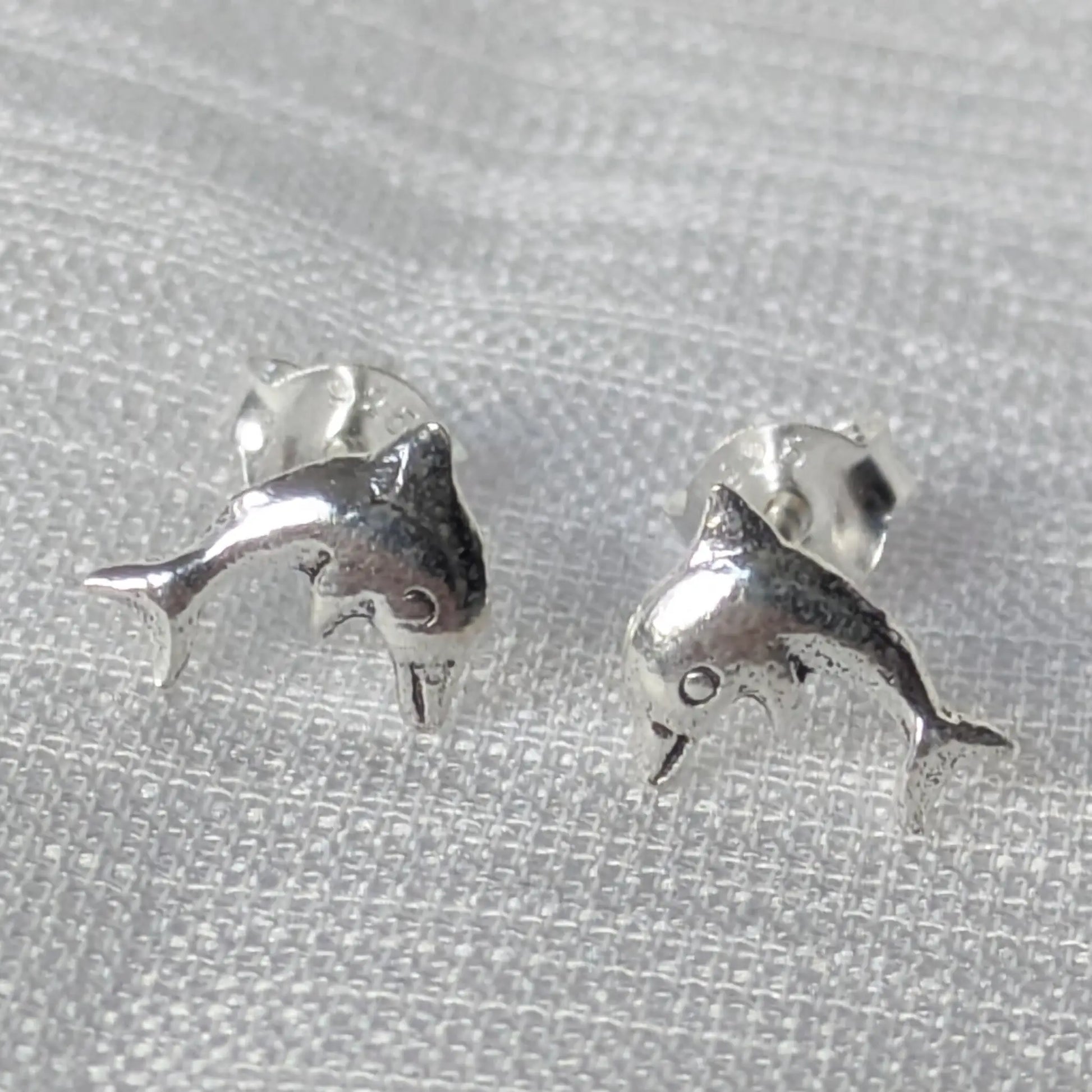 Frontale Ansicht der Delfin Silber Ohrstecker auf weißem Hintergrund
