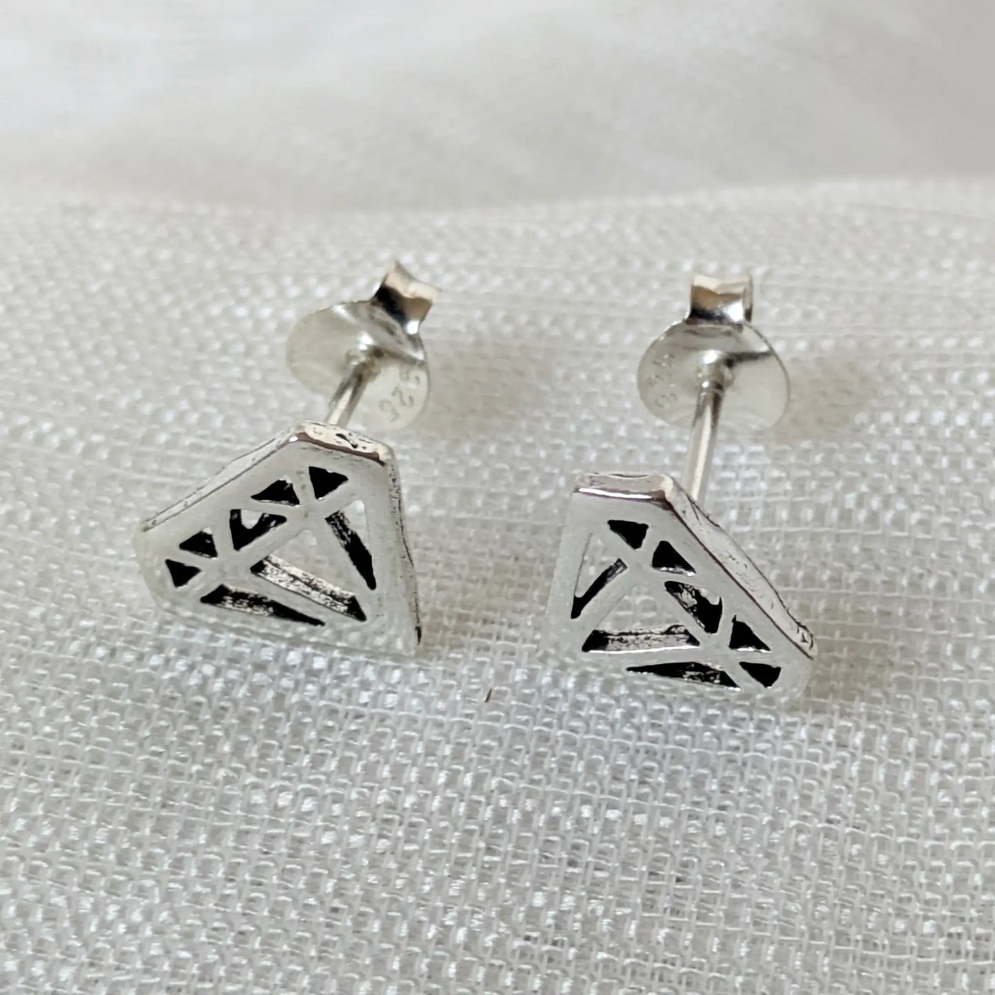 Frontalansicht der silbernen Diamond-Shape Ohrringe im filigranen, geometrischen Cutout-Design.
