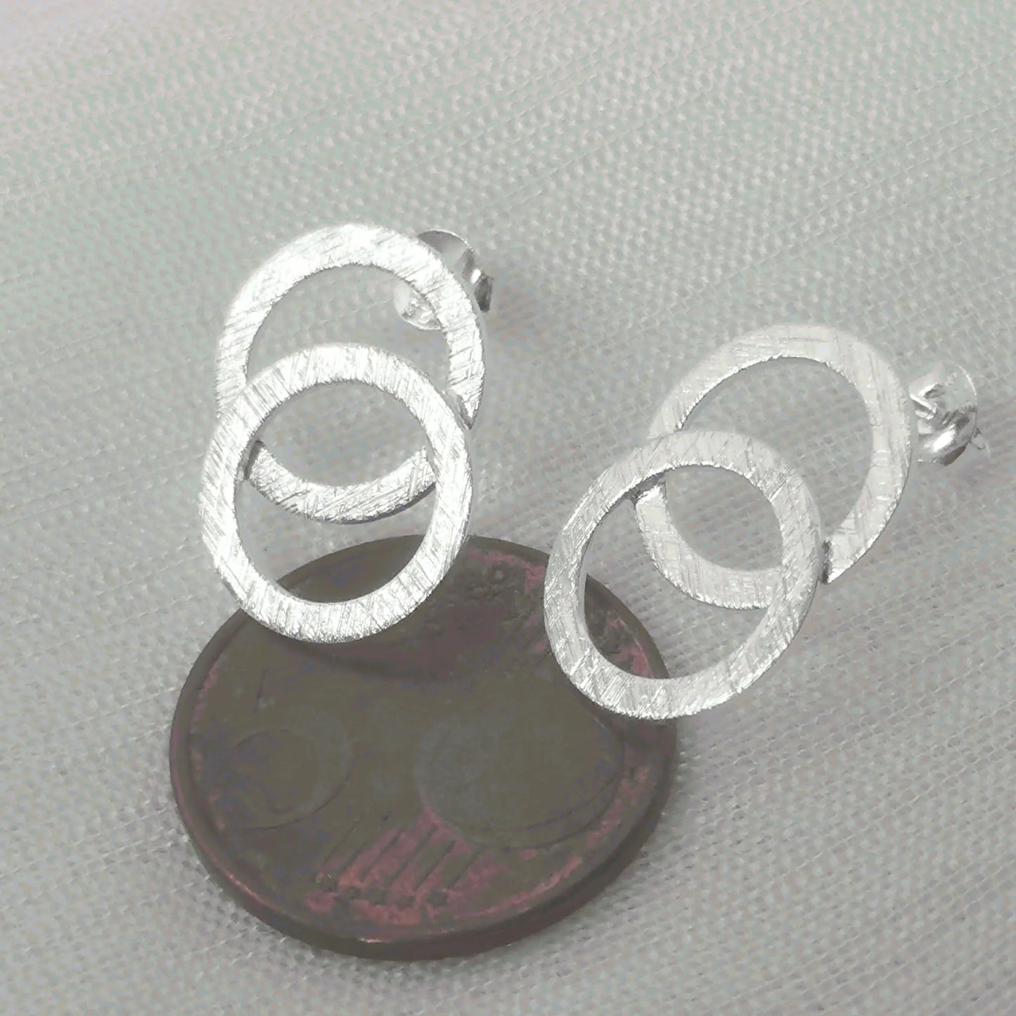 Größenvergleich der modernen, matten Kreis-Ohrringe aus 925 Silber platziert auf einer 5-Cent-Münze für eine reale Größenübersicht.