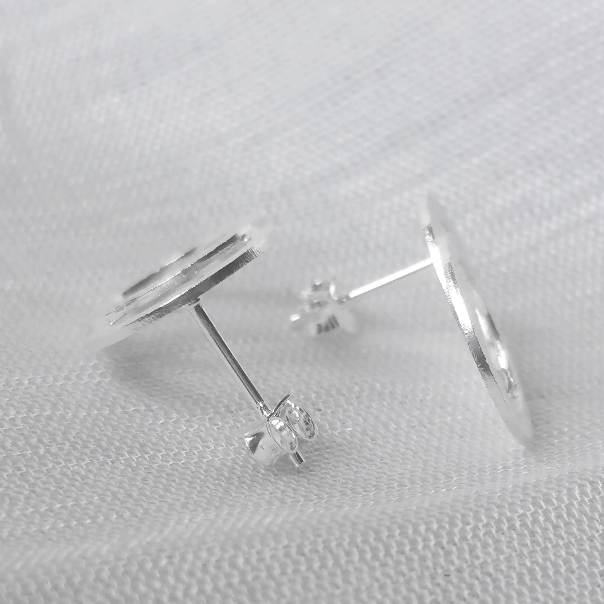 Seitenansicht der kratzmattierten Doppelkreis-Ohrringe aus Sterling Silber zur Veranschaulichung der flachen Form und des Steckverschlusses.