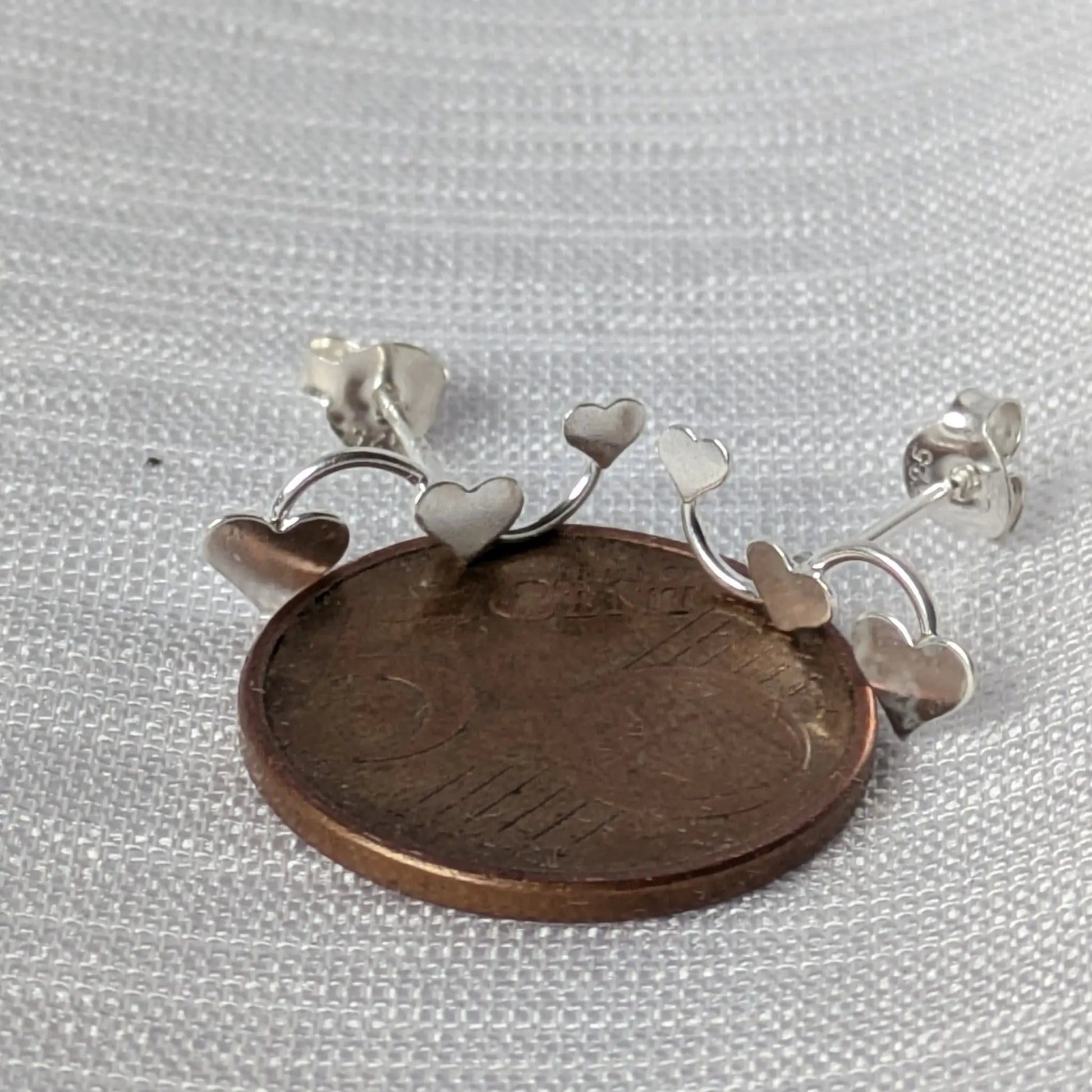 Größenvergleich der Herz-Ohrstecker auf einer 5-Cent Münze zur Maßstabsdarstellung.