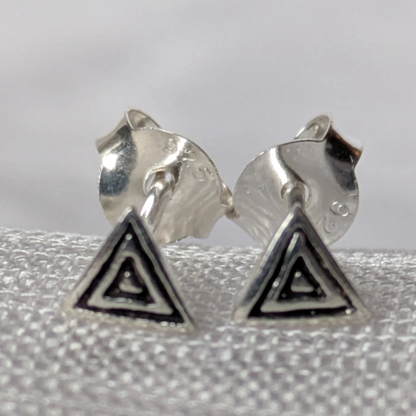Paar strukturierte Dreieck-Ohrstecker aus 925 Sterling Silber, freigestellt für eine detaillierte Produktansicht.