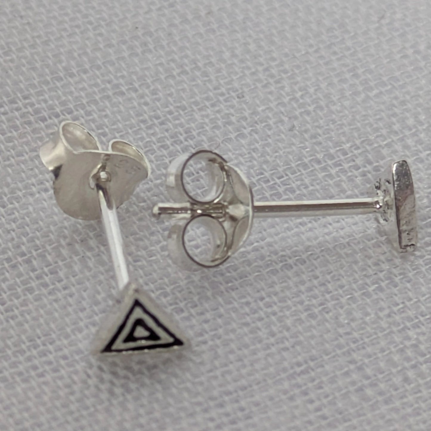 Seitenansicht der Triangle-Ohrringe; zeigt die flache Bauweise und die präzisen Kanten des Silberschmucks.