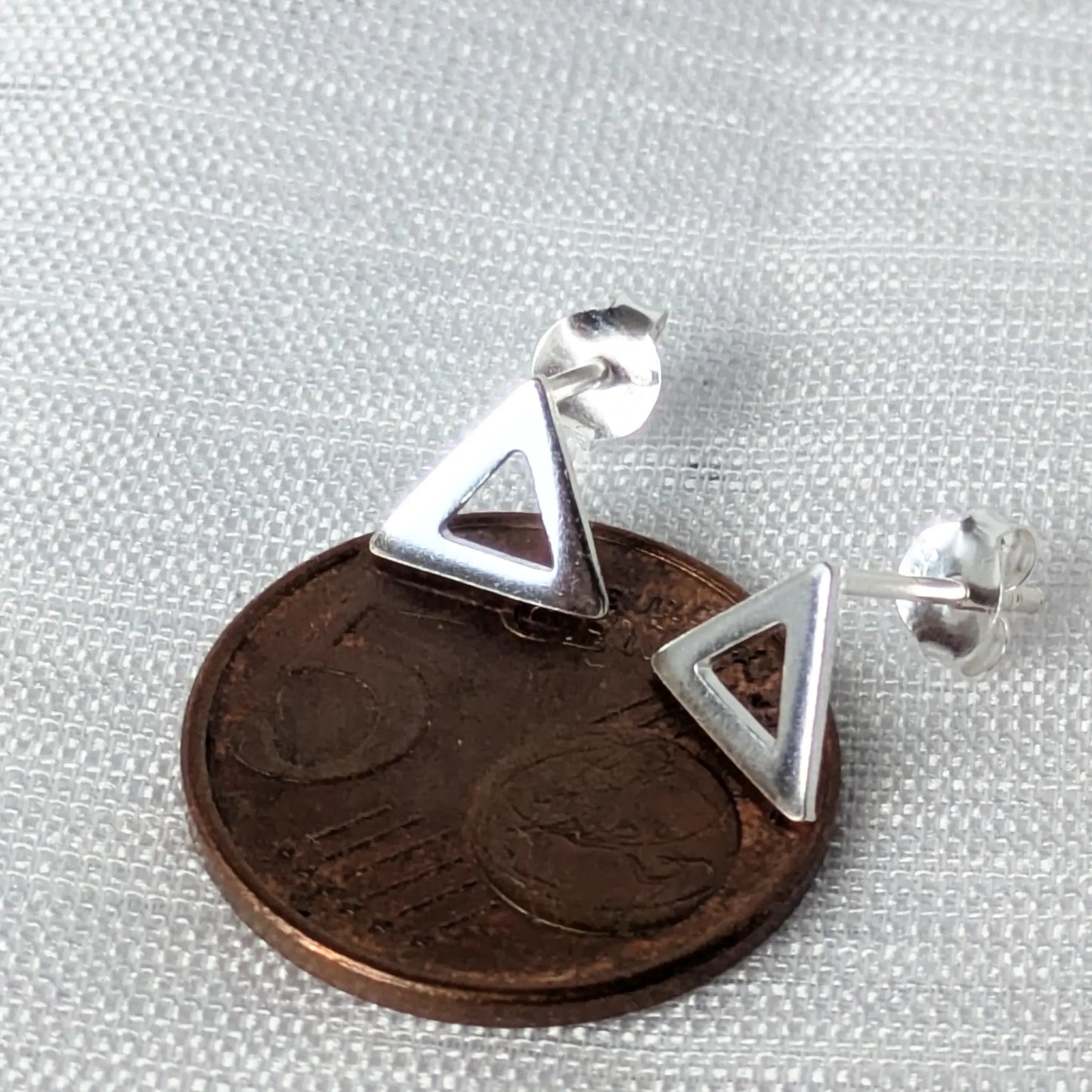 Größenvergleich von kleinen Dreieck-Ohrsteckern in 925 Silber auf einer 5-Cent-Münze