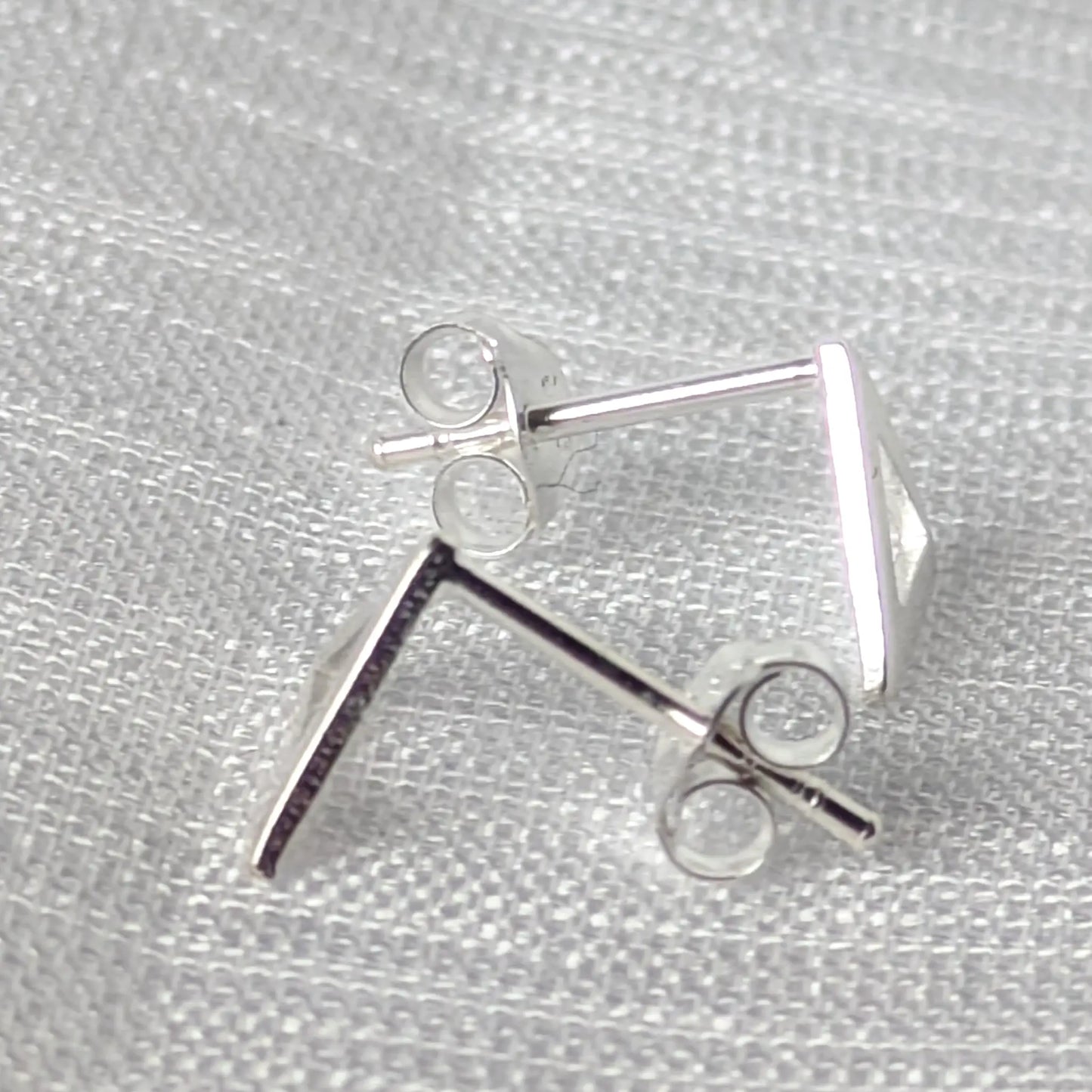 Seitenansicht der modernen Dreiecks-Ohrstecker aus glänzendem Silber