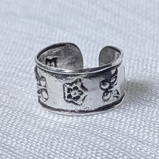 Nahaufnahme einer breiten Ohrklemme aus 925 Silber mit geprägtem Vintage Blumenmuster.