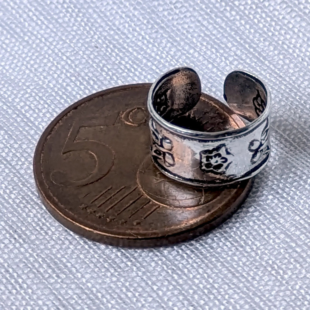 Größenvergleich der floralen 925 Silber Ohrklemme, platziert auf einer 5-Cent-Münze.