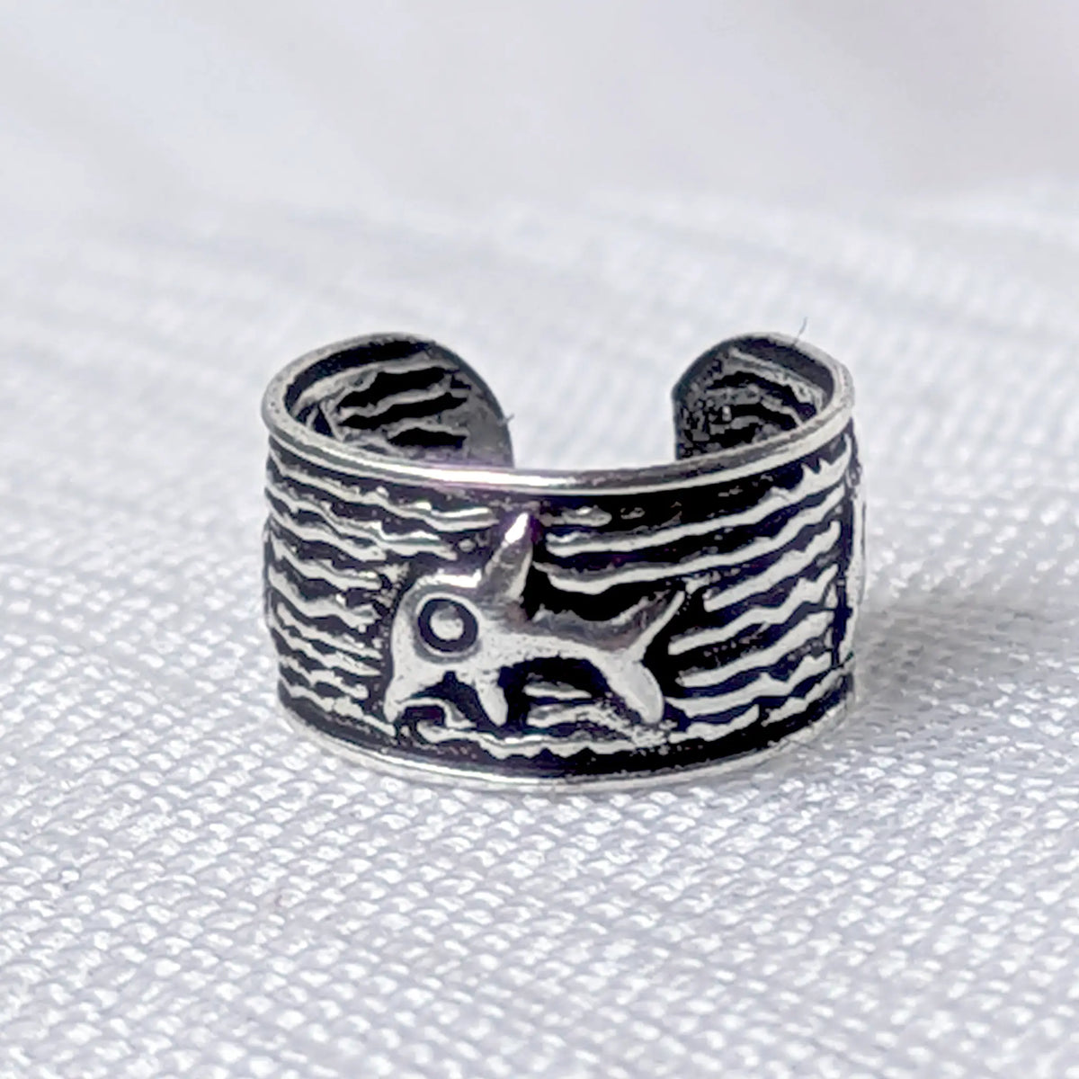 Frontalansicht der maritimen Silber-Ohrklemme im Vintage-Stil mit plastischer Delfin-Prägung.
