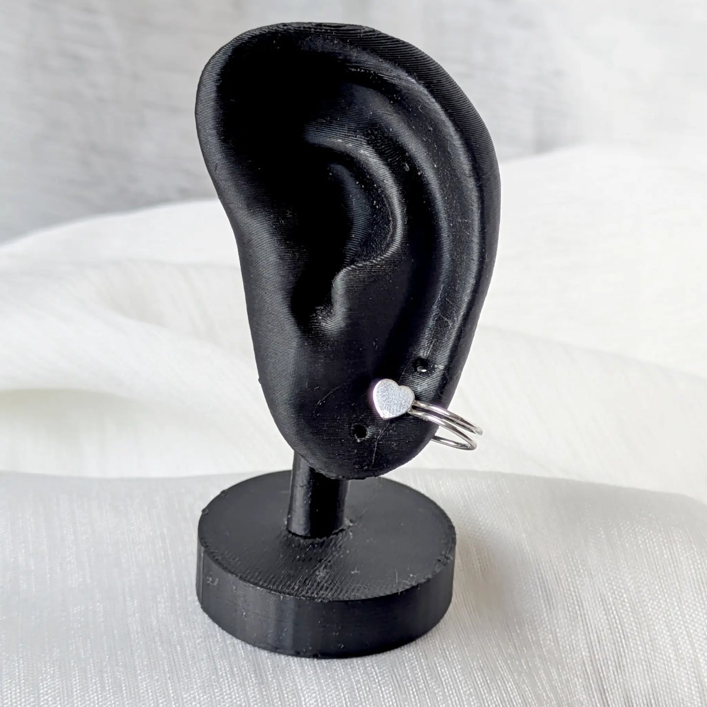 Herz 925 Silber Ear Cuff am Knorpel eines schwarzen Ohr-Displays getragen.