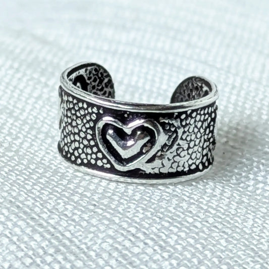 Nahaufnahme eines 925 Silber Ear Cuffs mit Herz-Motiv und geschwärzter Vintage-Struktur.